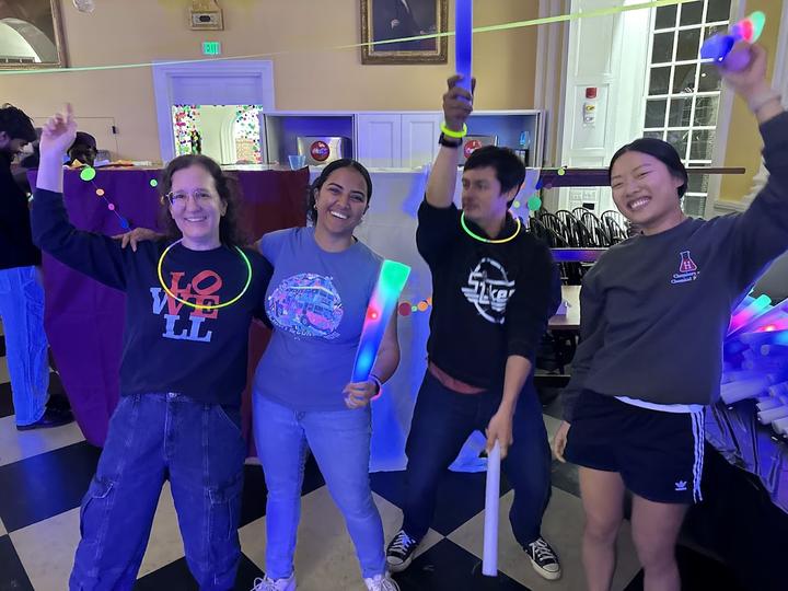 4 people dancing with glow sticks